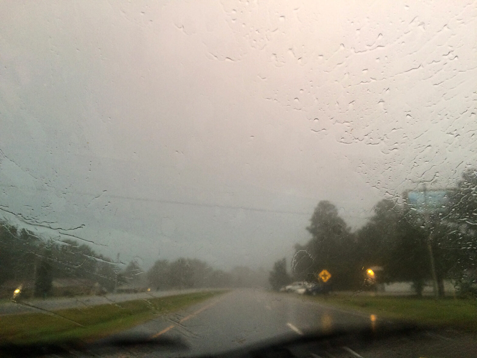 Looking out Front Car Window on Rainy Road at Dusk