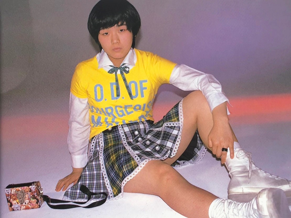 Photos of Seated Young Girl in Yellow T-Shirt and Short Checked Skirt, Part of Tokyo Love Essay by Nan Goldin