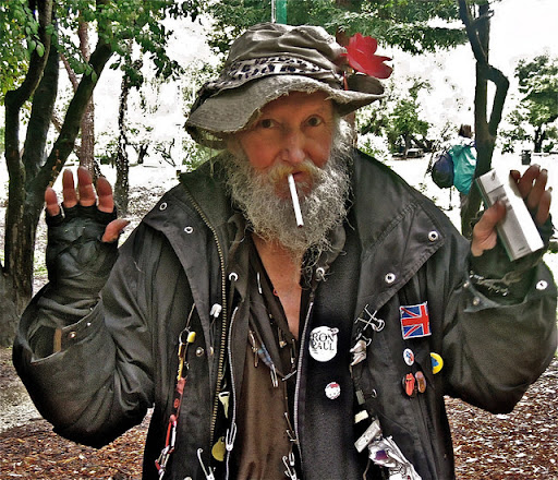 Berkeley's Hate Man Smoking Outdoors in Hat with Flower and Jacket with Political Buttons